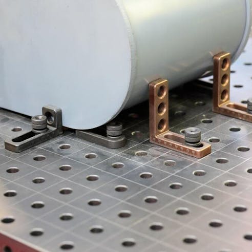 Workpiece mounted with clamps on metal welding table.  Image Credit: Shutterstock.com/genkur